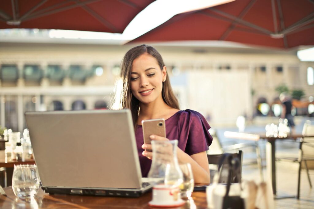 Woman-owned business owner in Boise checking her website and Google Business Profile on her phone and laptop